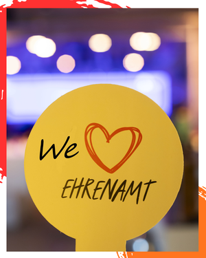 Ein gelbes Schild auf dem steht: We love Ehrenamt